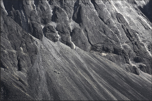 A dusting of snow on the dark rocks on the base of Mount Ama Dablam (6814 m)