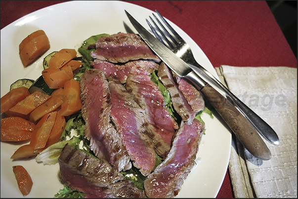 Gruba refuge. One of the typical dishes is the cut of cooked beef on the grill