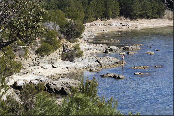 The coastal trail runs along the rocky bay before Léoube beach