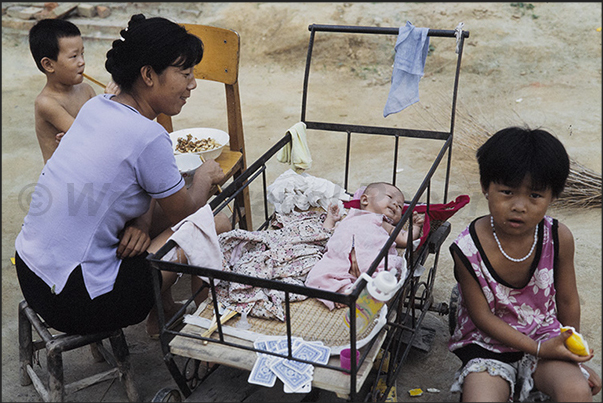 Mongin Village. As men work in the fields, women care for children
