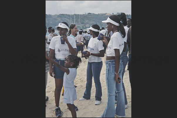 Before the start of the regatta, the public, composed by the families of the crews, crowds the beach Before the start of the regatta, the public, composed by the families of the crews, crowds the beach