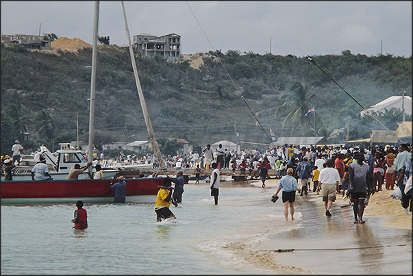 Before the start of the regatta, the public, composed by the families of the crews, crowds the beach Before the start of the regatta, the public, composed by the families of the crews, crowds the beach