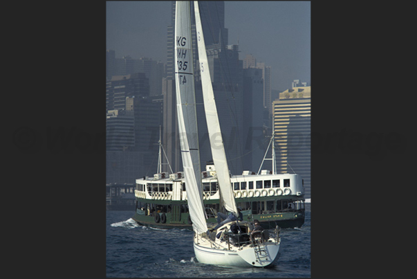 Junks, ferries and ships cross Victoria Harbor during day and night Junks, ferries and ships cross Victoria Harbor during day and night