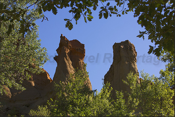 Pinnacles appear suddenly above the forest as guardians of Provencal Canyon paths