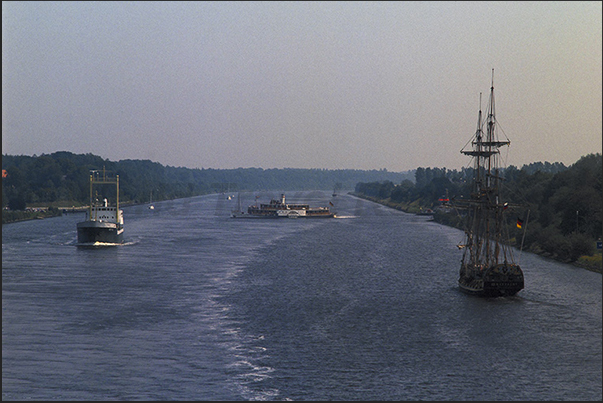 In navigation in Kiel Canal. Merchant ships, wheel steamers and sailing ships In navigation in Kiel Canal. Merchant ships, wheel steamers and sailing ships