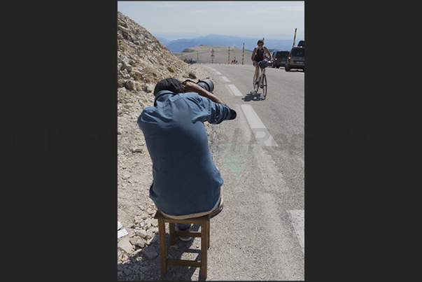 The arrival on the top of the mountain immortalized by the photographer who follows the cyclists