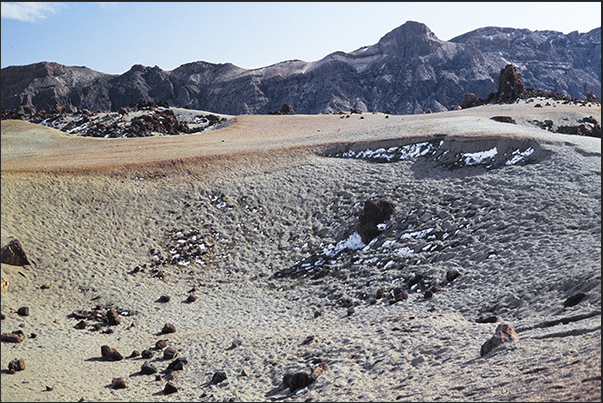 Snow and ice persist in the shadow of the rocks