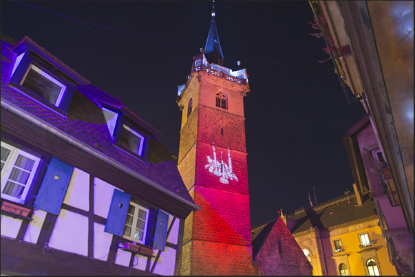 The bell tower in the market square in Obernai illuminated with colored lights during the Christmas season The bell tower in the market square in Obernai illuminated with colored lights during the Christmas season