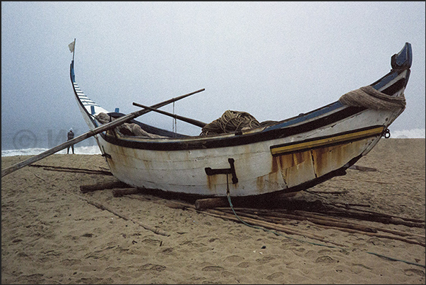 Leaning on long poles, the boats await the arrival of the fishermen and oxen to be lowered into the sea