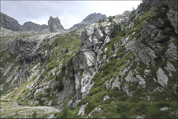 The rugged rock walls that delimit the valley where the Scarfiotti refuge is located The rugged rock walls that delimit the valley where the Scarfiotti refuge is located
