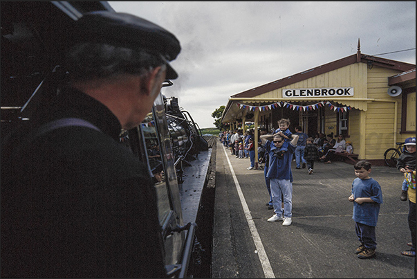The steam train enters in Glenbrook station in front of adults and children excited to begin the journey