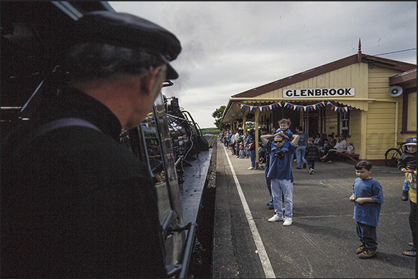 The steam train enters in Glenbrook station in front of adults and children excited to begin the journey The steam train enters in Glenbrook station in front of adults and children excited to begin the journey