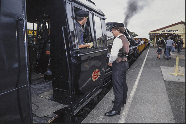 Train conductor and engineer wait for passengers to board Train conductor and engineer wait for passengers to board