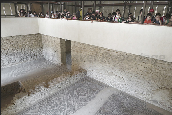 A balcony allows visitors to observe from above the mosaic floors that develop in the Roman villa