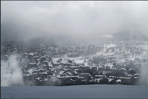 The clouds open up and appear the towns of Crans and Montana The clouds open up and appear the towns of Crans and Montana