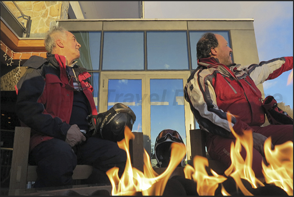 Two chats around the fire after a day of skiing to observe the alpine circle at sunset Two chats around the fire after a day of skiing to observe the alpine circle at sunset