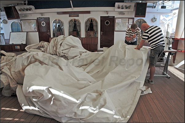 During the night, the wind tore a sail. The next day, the tailors repair the sail with needle and thread