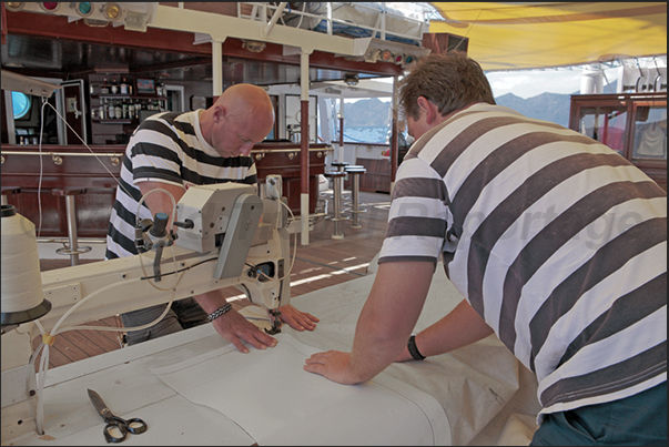 During the night, the wind tore a sail. The next day, the tailors repair the sail with needle and thread During the night, the wind tore a sail. The next day, the tailors repair the sail with needle and thread