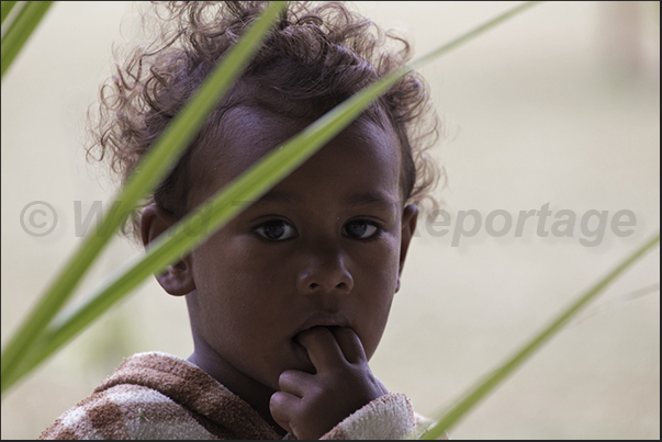 Children look their mothers while preparing floral ornaments