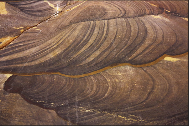 On the walls of the canyon, layers of oxides create fantastic designs