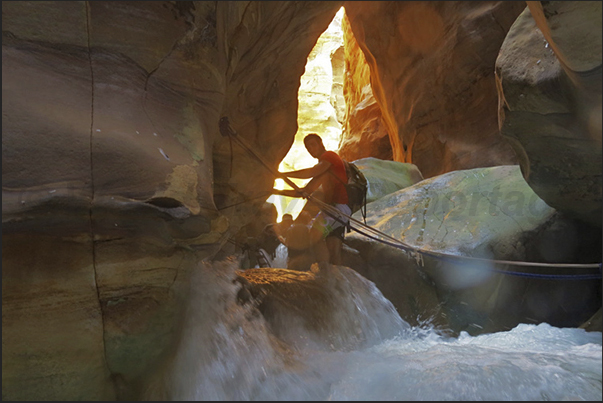 A few easy steps to overcome the little falls of the canyon using the fixed ropes attached to the walls