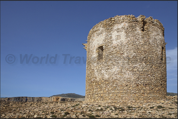 The ancient Spanish watchtower (eighteenth century) at the entrance to Cala Domestica Bay The ancient Spanish watchtower (eighteenth century) at the entrance to Cala Domestica Bay