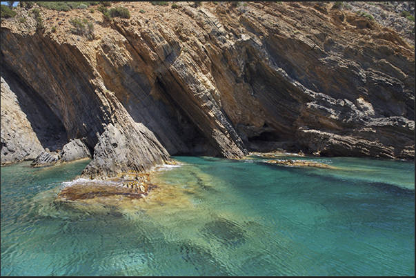 The cliff between Cala Domestica Bay and Porto Flavia. A paradise for anyone who rents a small boat for cruise along the coast The cliff between Cala Domestica Bay and Porto Flavia. A paradise for anyone who rents a small boat for cruise along the coast