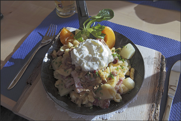 The revolving restaurant Piz Gloria (2970 m). A Rosti typical dish made with potatoes, meat, cheese and egg served very hot