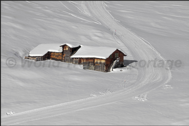 The slopes of the Lauberhorn mountain pass near the huts that, in the summer, are the home of farmers and cows The slopes of the Lauberhorn mountain pass near the huts that, in the summer, are the home of farmers and cows