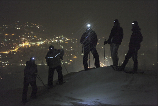 Night walk with snowshoes above the village of Grindelwald Night walk with snowshoes above the village of Grindelwald