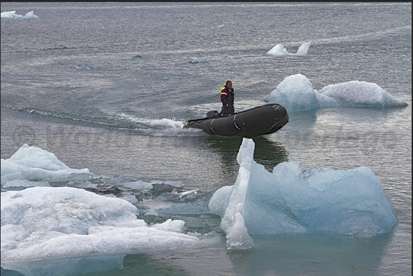 Rangers of the National Park between iceberg on the lake formed by Jokulsarlon Glacier Rangers of the National Park between iceberg on the lake formed by Jokulsarlon Glacier