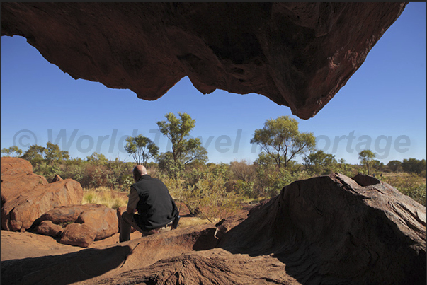 Uluru-Kata Tjuta National Park. A moment of rest of a park guard near a cave Uluru-Kata Tjuta National Park. A moment of rest of a park guard near a cave