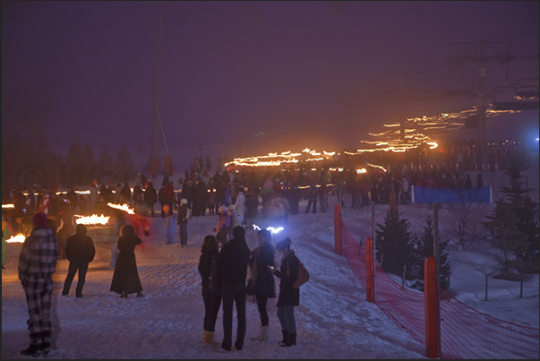 Festive evening on the Croisette in Les Menuires. The torchlight procession of teachers and students in the fog