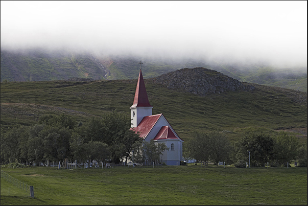 Along the Eyjafjordur Fjord, there are small countries like Holl with his church that stands out among the green fields Along the Eyjafjordur Fjord, there are small countries like Holl with his church that stands out among the green fields