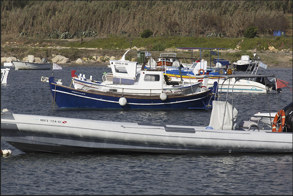 A small fishing port with fishing boats and boats of tourists