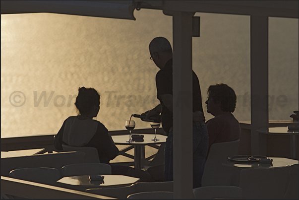 A glass of local wine at sunset is a custom of the tourists who visit the island. A glass of local wine at sunset is a custom of the tourists who visit the island.