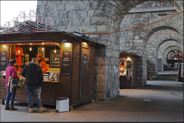 Among the stone arches that line the Europa square, pubs and Christmas stands Among the stone arches that line the Europa square, pubs and Christmas stands