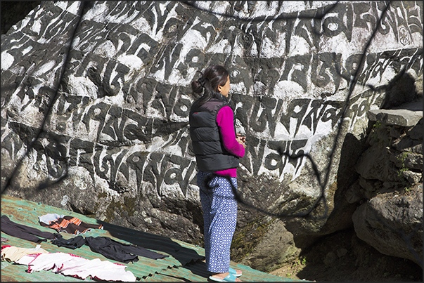 Chheplung (2660 m). In prayer in front of the stone prayers Chheplung (2660 m). In prayer in front of the stone prayers