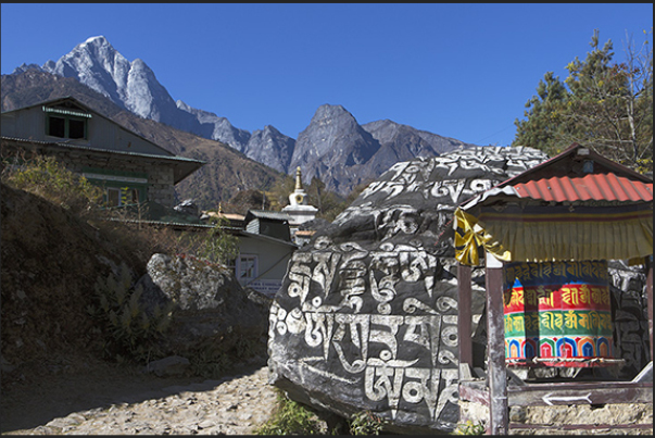Village of Ghat-Nurning (2592 m). Stones and cylinder prayer before a Stupa (sacred monument) Village of Ghat-Nurning (2592 m). Stones and cylinder prayer before a Stupa (sacred monument)