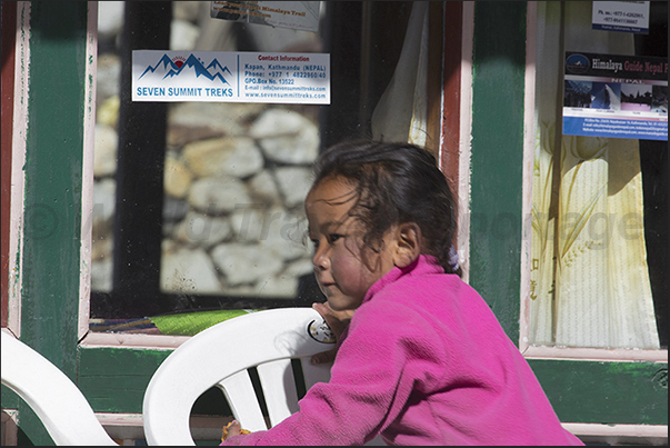 Along the road through the village of Pangboche, children observe the passage of tourists Along the road through the village of Pangboche, children observe the passage of tourists