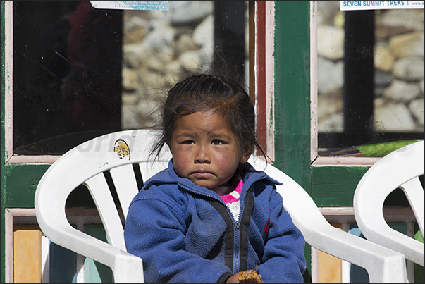 Along the road through the village of Pangboche, children observe the passage of tourists Along the road through the village of Pangboche, children observe the passage of tourists