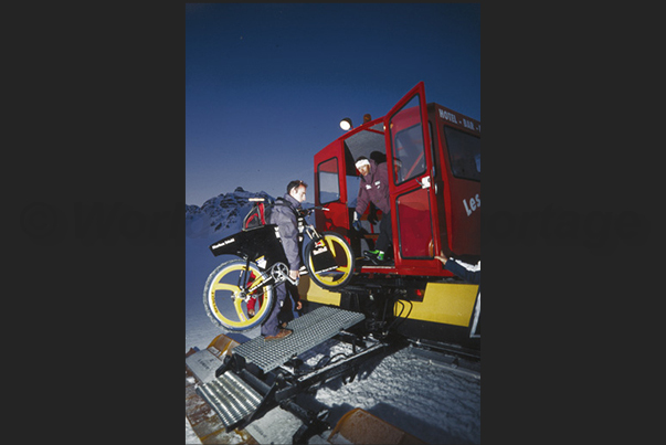 Before the sunrise, the bicycles are loading on the tractor to bring them at the arrival of the slope Before the sunrise, the bicycles are loading on the tractor to bring them at the arrival of the slope