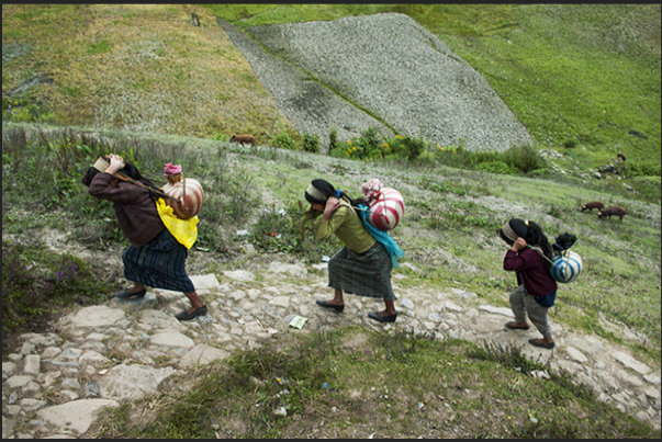 San Mateo Ixtatan, three girls back to the house carrying on his shoulders the water pitchers filled at the well San Mateo Ixtatan, three girls back to the house carrying on his shoulders the water pitchers filled at the well