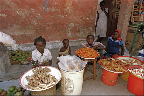 In the street, young women sell fruit, pastries and bread In the street, young women sell fruit, pastries and bread