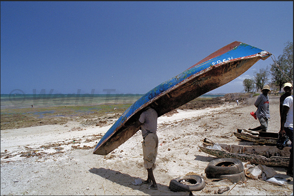 A fisherman performs some simple maintenance to his pirogue A fisherman performs some simple maintenance to his pirogue