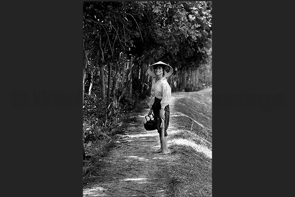 A woman carries her teapot to the farmers for a little moment of rest A woman carries her teapot to the farmers for a little moment of rest