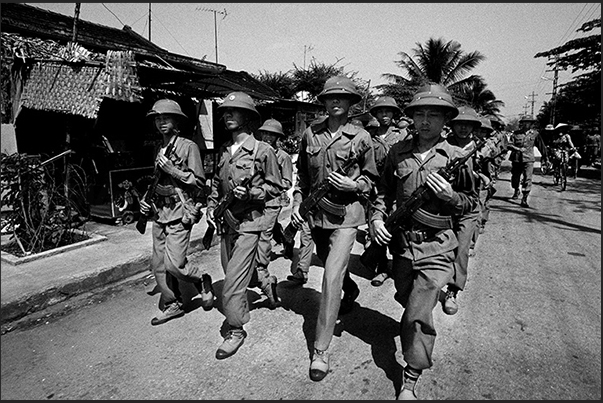 A group of soldiers passing through the streets of a village A group of soldiers passing through the streets of a village