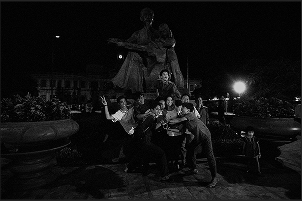 Ho Chi Minh City (Saigon). A group of young people on Saturday night, are having fun under the statue of Ho Chi Ming Ho Chi Minh City (Saigon). A group of young people on Saturday night, are having fun under the statue of Ho Chi Ming