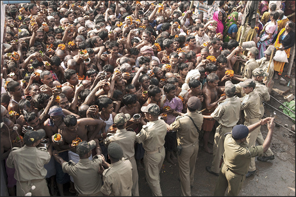 Pilgrims waiting their turn to make the offer to the Harihar Nath Tample carrying jugs with water from the holy river and flowers