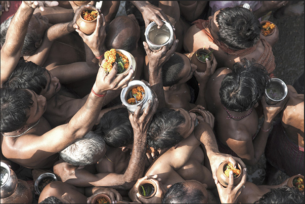 Pilgrims waiting their turn to make the offer to the Harihar Nath Tample carrying jugs with water from the holy river and flowers